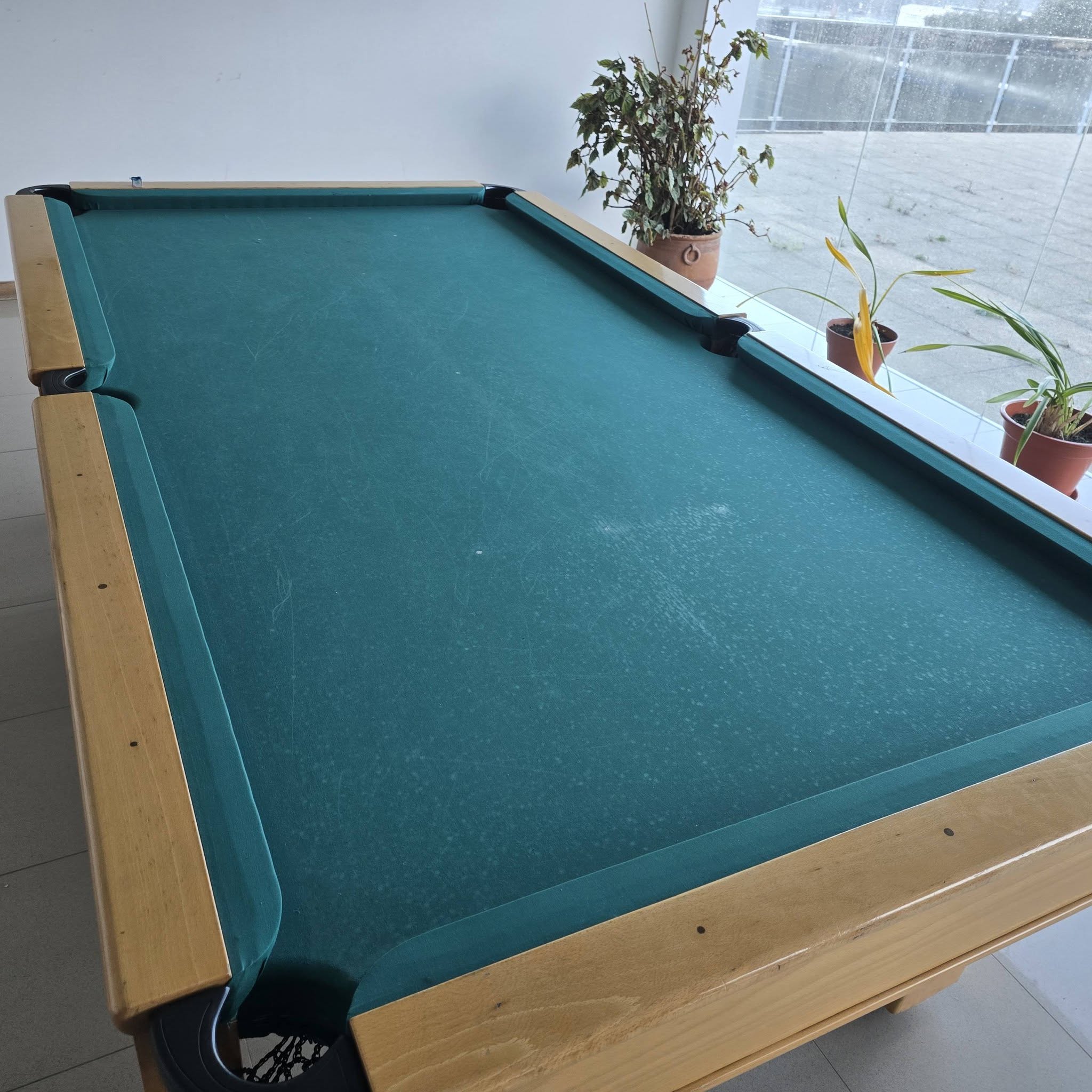 Mesa de pool com pano verde desgastado e manchado, antes da intervenção
